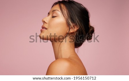 Side view of asian woman with beautiful skin. Female model with flawless skin on pink background. Royalty-Free Stock Photo #1956150712