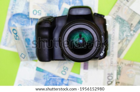 
photo camera on a background of polish zloty of different denominations. Earning money by taking photos. Work as a photo, earning on passion. Passive income