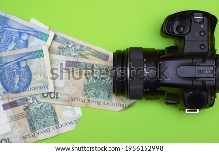 
photo camera on a background of polish zloty of different denominations. Earning money by taking photos. Work as a photo, earning on passion. Passive income