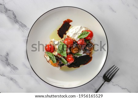 
Burrata Salad confit tomatoes - balsamic reduction - with fresh herbs, on white background 