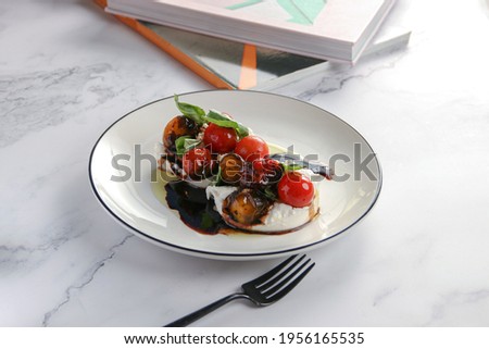 
Burrata Salad confit tomatoes - balsamic reduction - with fresh herbs, on white background 