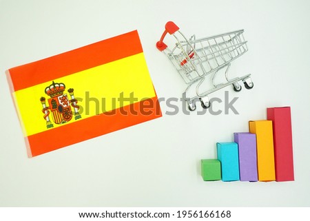 Spain national flag with miniature shopping trolley and colorful diagram isolated on white background