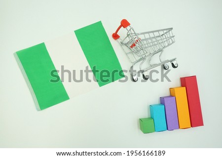 National flag of nigeria with miniature shopping trolley and colorful diagram isolated on white background