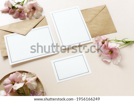 card  mockup template with pink  flowers on beige background top view.Wedding, greetings, invitation  paper blank.Copy space.