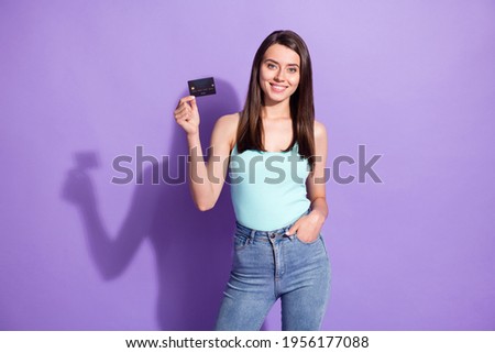 Photo of happy cheerful pretty woman hold hand pocket credit card isolated on purple color background