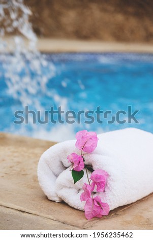 White towel with pink flowers near the spa pool in the hotel on vacation. High quality photo
