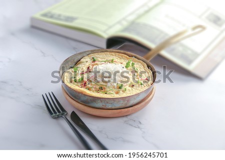 fried omelet egg with white cheese in the top, Fried egg, on White wood background