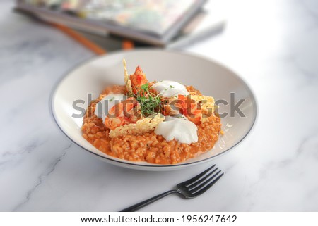 Tiger Prawn Risotto
Tiger prawn risotto with parmesan foam and crispy parmesan, on white background 
