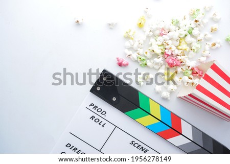 Movie clapper board and popcorn on white background 