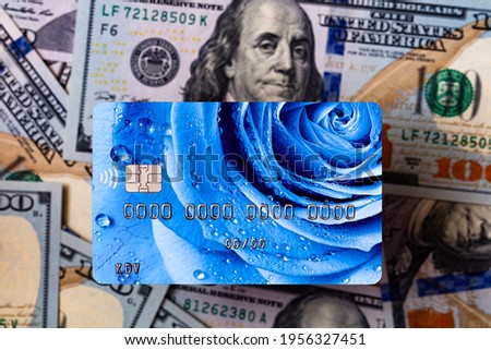 Debit card with rose design on US 100 dollar banknotes background for design purpose