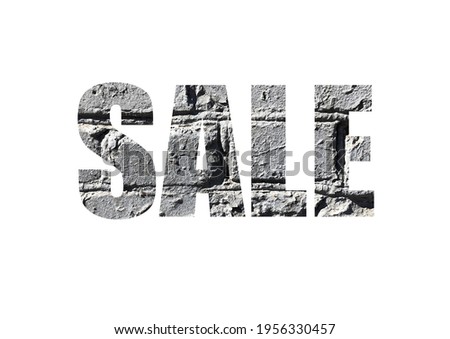 gray brick background. Shot through the cut-out silhouette of the word SALE.