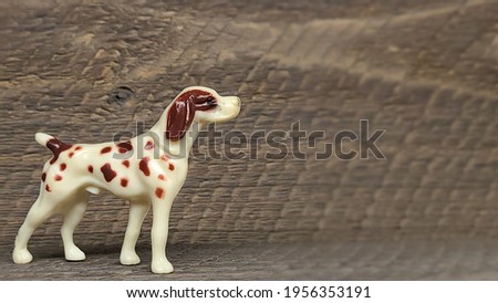 Dog figurine on brown wood background 