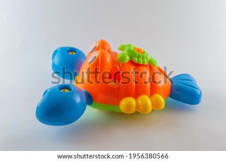  plastic crayfish toy. Isolated on white background with natural shadow. Cute orange and blue plastic crayfish for small children to play. Lobster plaything on white bg.