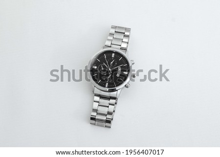 Luxury silver men's watch on white table. Monochromatic concept. Complementary color concept