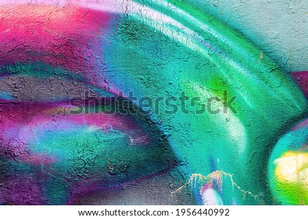 A fragment of colorful graffiti painted on a wall. Abstract urban background for design.