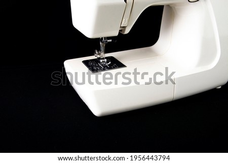 White sewing machine on a black background.
