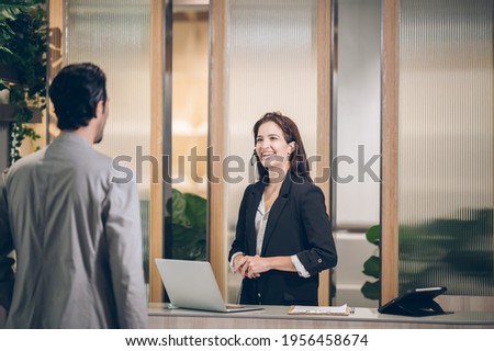 Receptionist  at hotel front desk  welcoming at Counter  Royalty-Free Stock Photo #1956458674