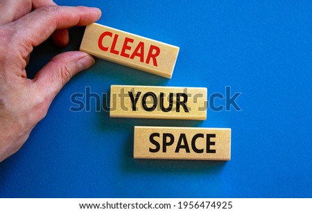 Clear your space symbol. Wooden blocks with words 'Clear your space'. Beautiful blue background, businessman hand. Business, clear your space concept, copy space.