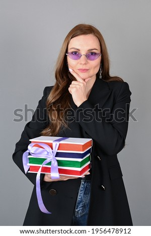 Young woman holding colorful books with ribbon on gray surface.Concept of knowledge and education.List of books to read. High quality photo