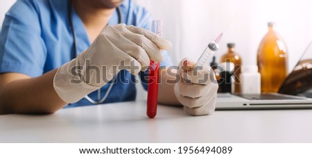 Concept fight against virus covid-19 corona virus, doctor or scientist in laboratory holding a syringe with liquid vaccines for children or older adults,Concept:diseases,medical care,science.