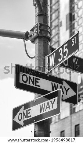 Black and white picture of One Way road signs at West 35th Street in New York City, USA.