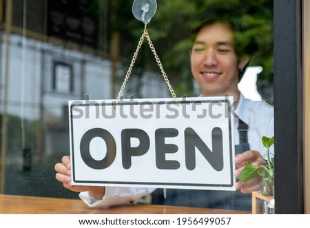 Barista or coffee maker man hold banner of open for the symbol of ready to service for customer. Concept of happy working with small business and sustainable.