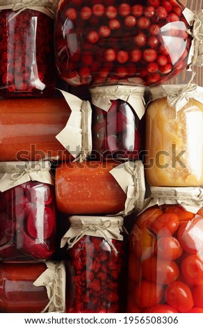 Assortment of canned vegetables and fruits- food in plastic free jars on wooden rustic table, flat lay, from above overhead top view, canned produce, saving leftovers food storage organization concept
