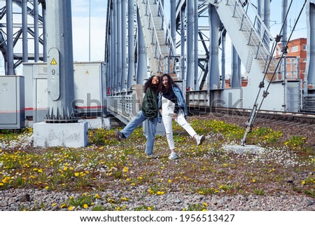young cute teenage girls together in industrial zone happy smiling having fun, big city lifestyle fashion people