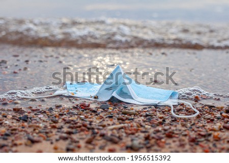 A medical mask thrown out of the sea pollutes nature.