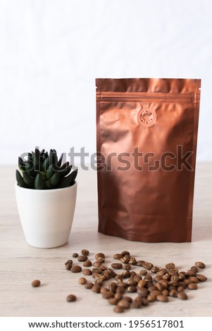 Blank coffee packaging on a wooden table, with coffee seeds, with decorative flower on a white background, coffee packaging mockup with empty space to display your branding design.
