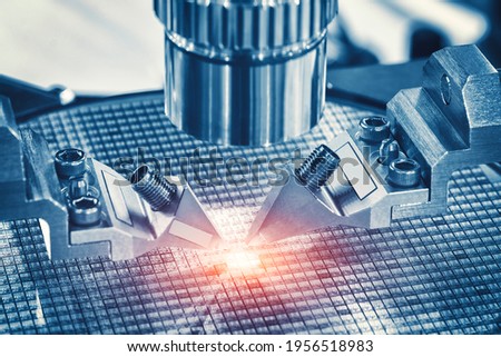 Close up of examining of test sample of microchip transistor under the microscope in laboratory. Equipment for testing microchips. Automation of production. Manufacturing of microchips. Royalty-Free Stock Photo #1956518983