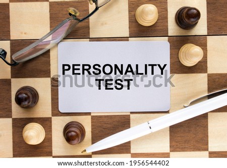 Business card with text Personality Test on a chess board with pen and eyeglasses. Concept photo