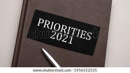 priorities 2021 sign written on the black sticker on the brown notepad. Tax concept