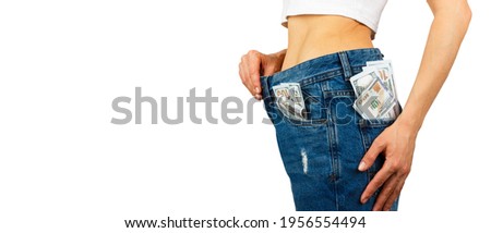 Woman in jeans with hundred dollars inside, light background