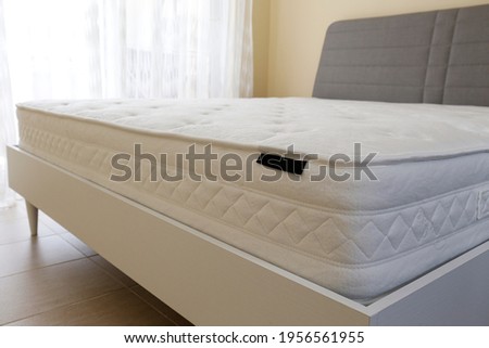 White orthopedic mattress top side surface pattern on unmade bed in the bedroom. Hypoallergenic foam matress for proper spinal alingment and pressure point relief. Background, copy space, close up. Royalty-Free Stock Photo #1956561955