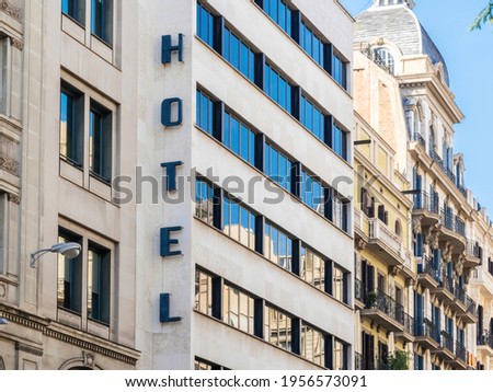 Vintage 70s building with Hotel lettering inscription signage in the Catalan capital Barcelona, Spain - real estate properties in background