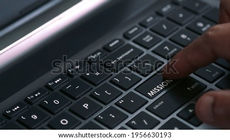 User finger press laptop keyboard button with MISSION word. Concept for business and marketing. Selective focus
