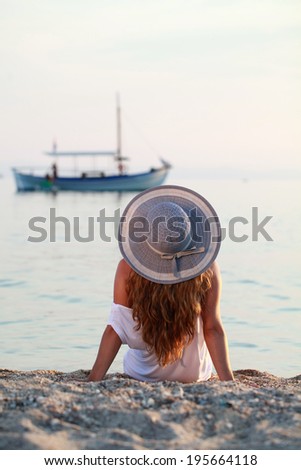 young lady is enjoying the summer sea sunset, on the beautiful beach, in front of the sea