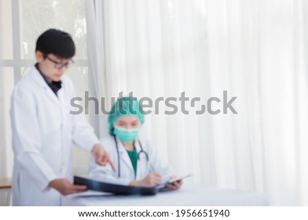 Blur picture about Two doctor look and discussion about an X-ray  of the patient's at office in hospital,Medical service and healthcare concept.
