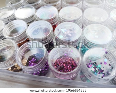 Picture of colorful different nail glitter. Nail polish isolated on white background.
