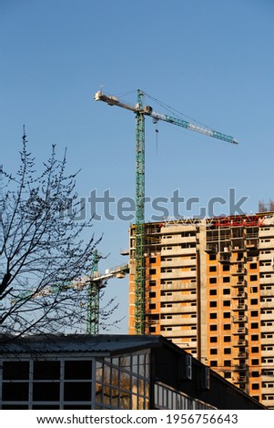 High-rise crane and residential buildings at the background of a blue sky