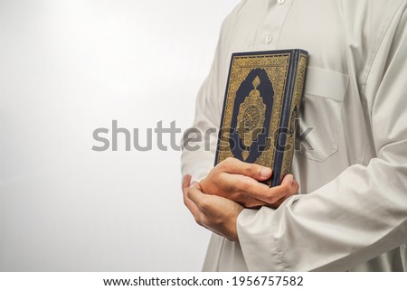 close up hand holding a holy Qur'an Royalty-Free Stock Photo #1956757582