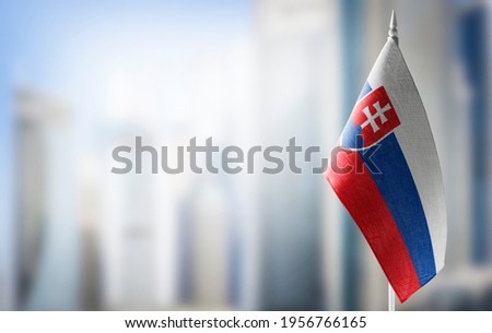 A small flag of Slovakia on the background of a blurred background