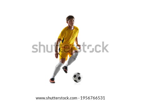 Young man, male soccer football player training isolated on white background.