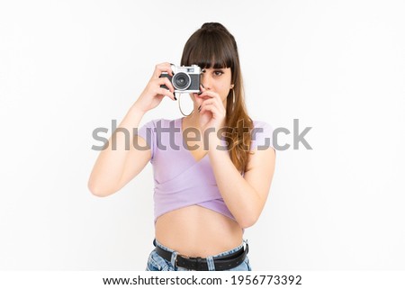 Woman taking picture with photo camera on white background