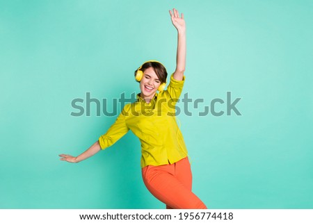 Photo portrait of overjoyed entertaining on weekend in headphones girl laughing isolated on vibrant turquoise color background