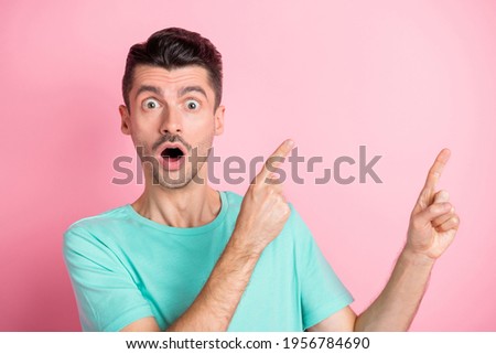 Photo of young man amazed shocked surprised indicate fingers empty space ad promo advice isolated over pink color background