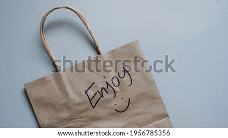 Enjoy word on brown shopping bag.