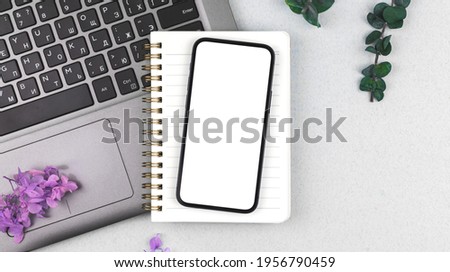 Business flat lay background with smartphone screen mockup, laptop keyboard and colorful flowers on the desktop