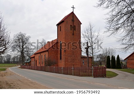 built in the neo-Gothic style of red ceramic brick in 1921, the Catholic Church of St. Andrew the Apostle in the village of Prawdziska in Masuria, Poland. The photos show a general view of the temple.